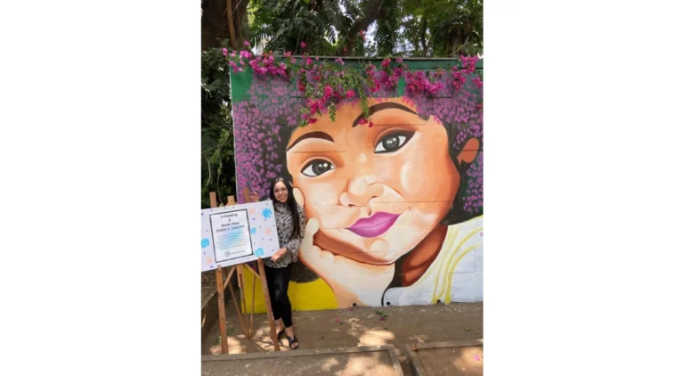 Colorful outdoor wall mural of a girl’s face celebrating childhood innocence, painted by a top wall mural artist in India.